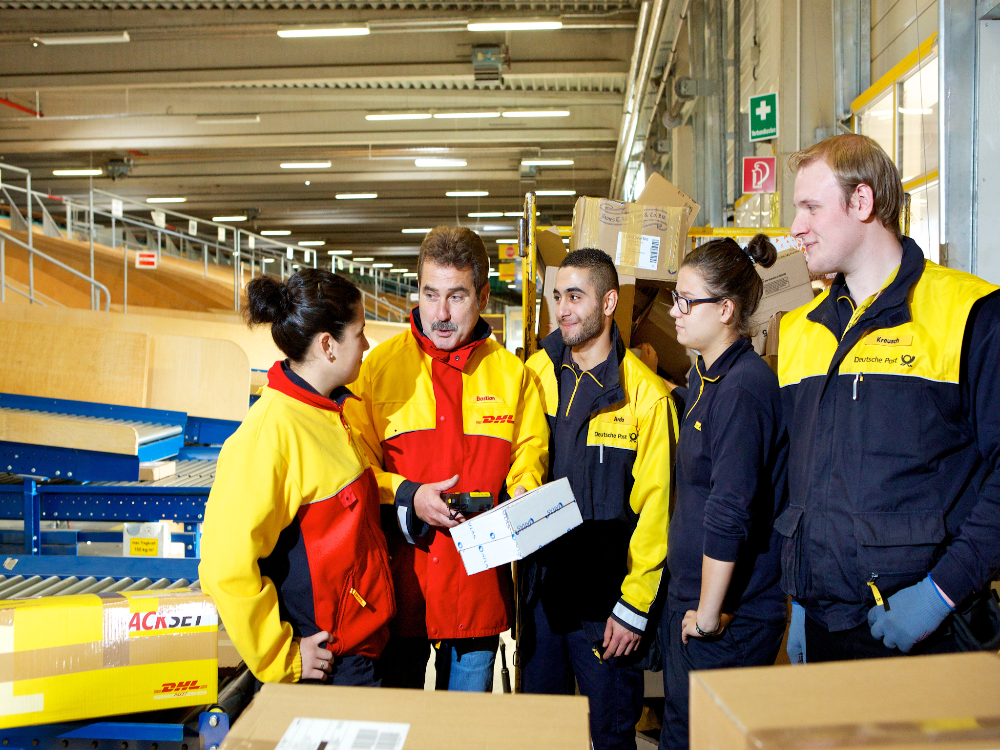 dhl-deutsche-post-trainees-tutor-parcel-sorting-machine Arbeit im Team als Sortierer bei der Deutschen Post. Foto: Deutsche Post AG