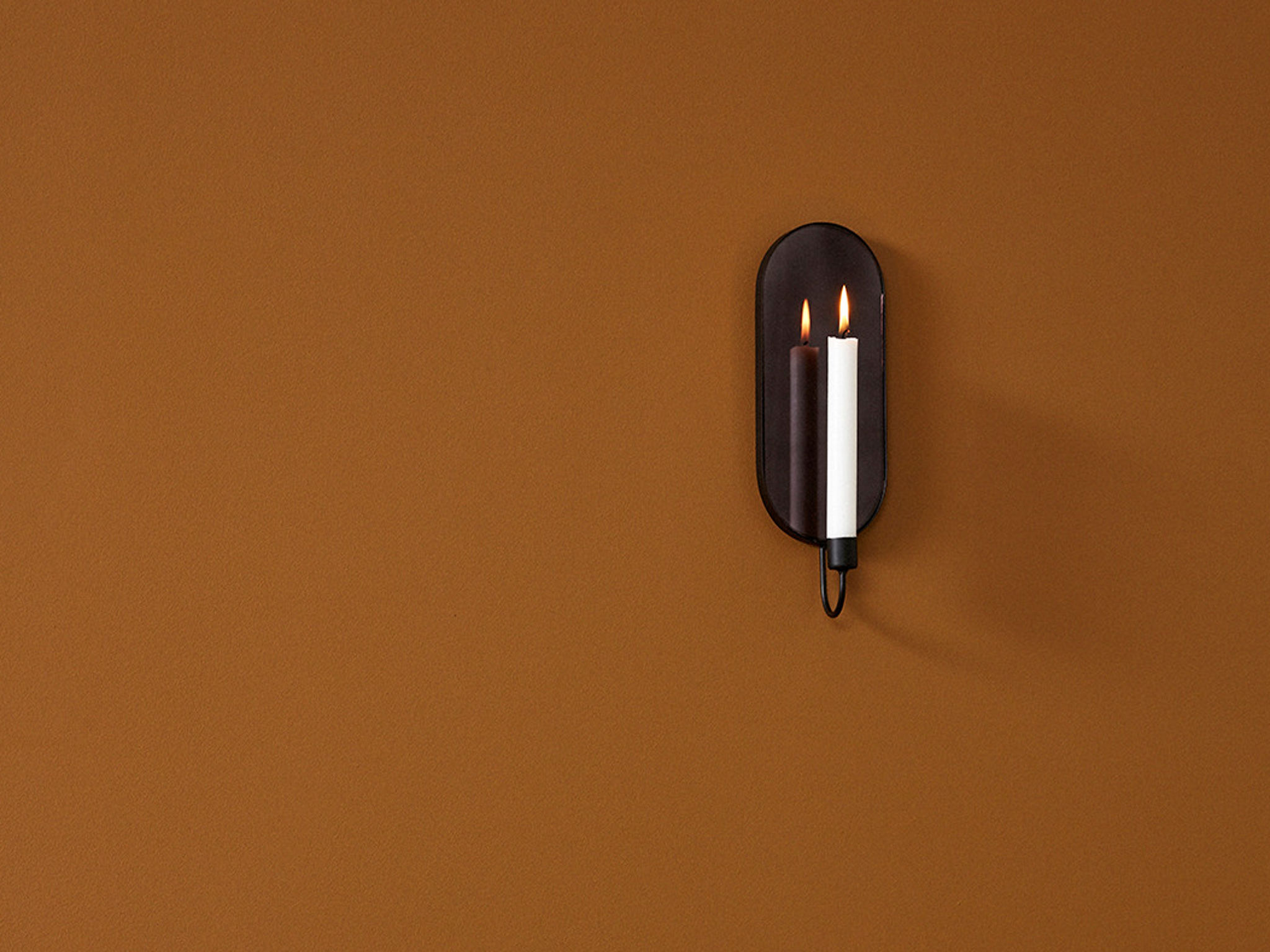 Schlichte Eleganz: Der Spiegel mit Kerzenhalter ist ein Hingucker. Foto: einrichten design