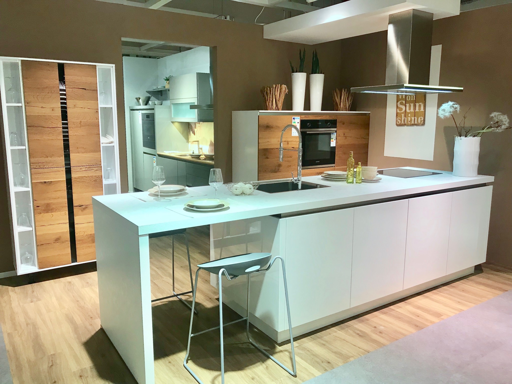 Schnell sein lohnt sich: Designküche mit Absatzfronten in Echtholzfurnier, integrierter Sitzgelegenheit und Markengeräteausstattung im Angebot! Foto: MEDA Gute Küchen