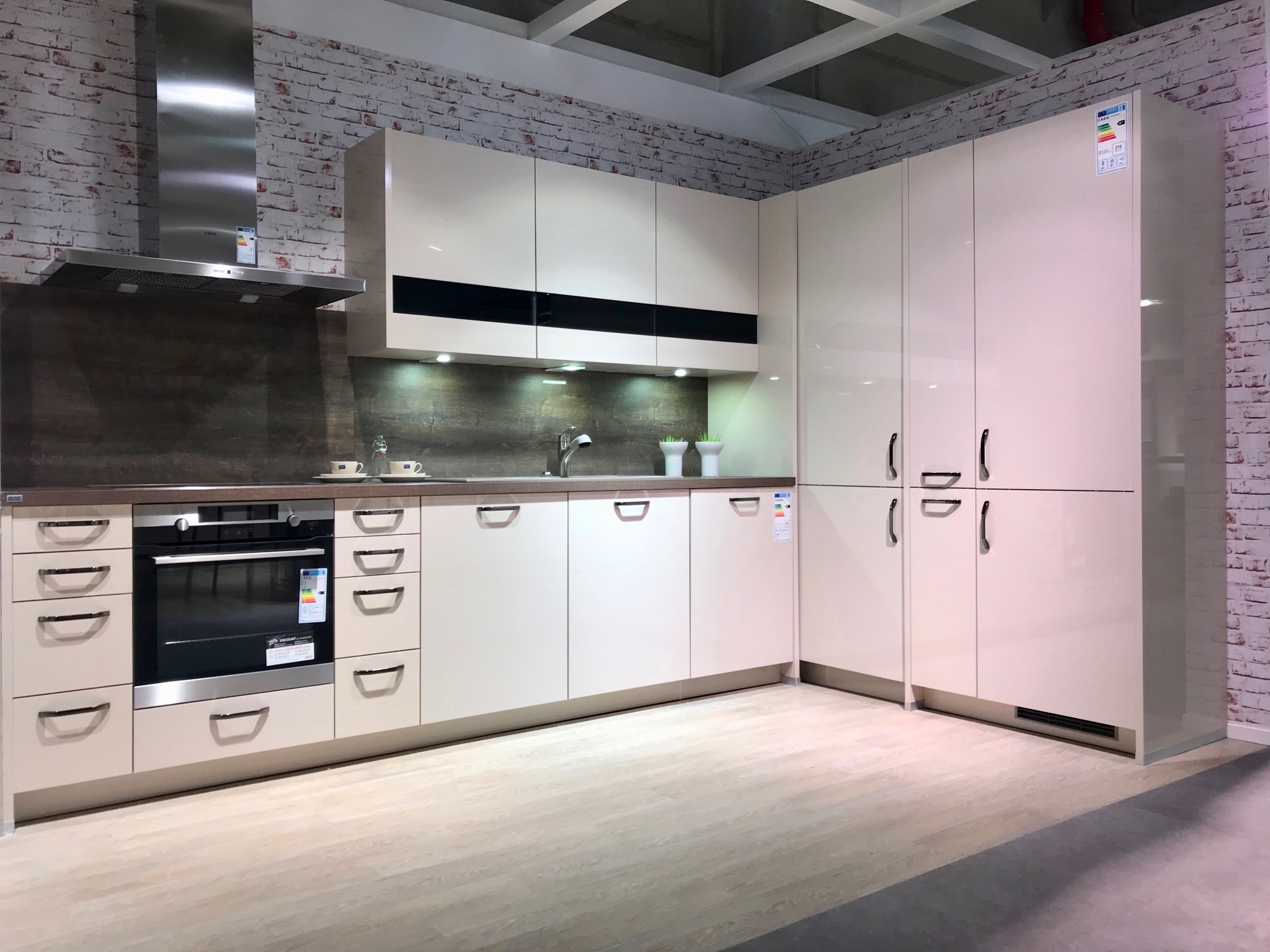 Ausstellungsküchen günstig zu haben: Moderne Küche mit begehbarem Eckschrank und Keramikspüle mit farblich passender Armatur. Foto: MEDA Gute Küchen