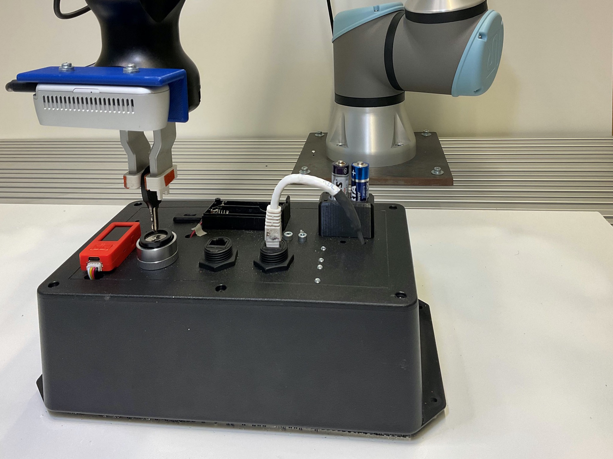Der Roboter ist dabei, einen Schlüssel in ein Schloss einzuführen und nutzt dabei seine Feinfühligkeit. Das „Task Board“ erkennt die erfolgreiche Durchführung der Aufgaben durch Sensorik und misst gleichzeitig die dafür benötigte Zeit. Foto: Elhasan Mohamed