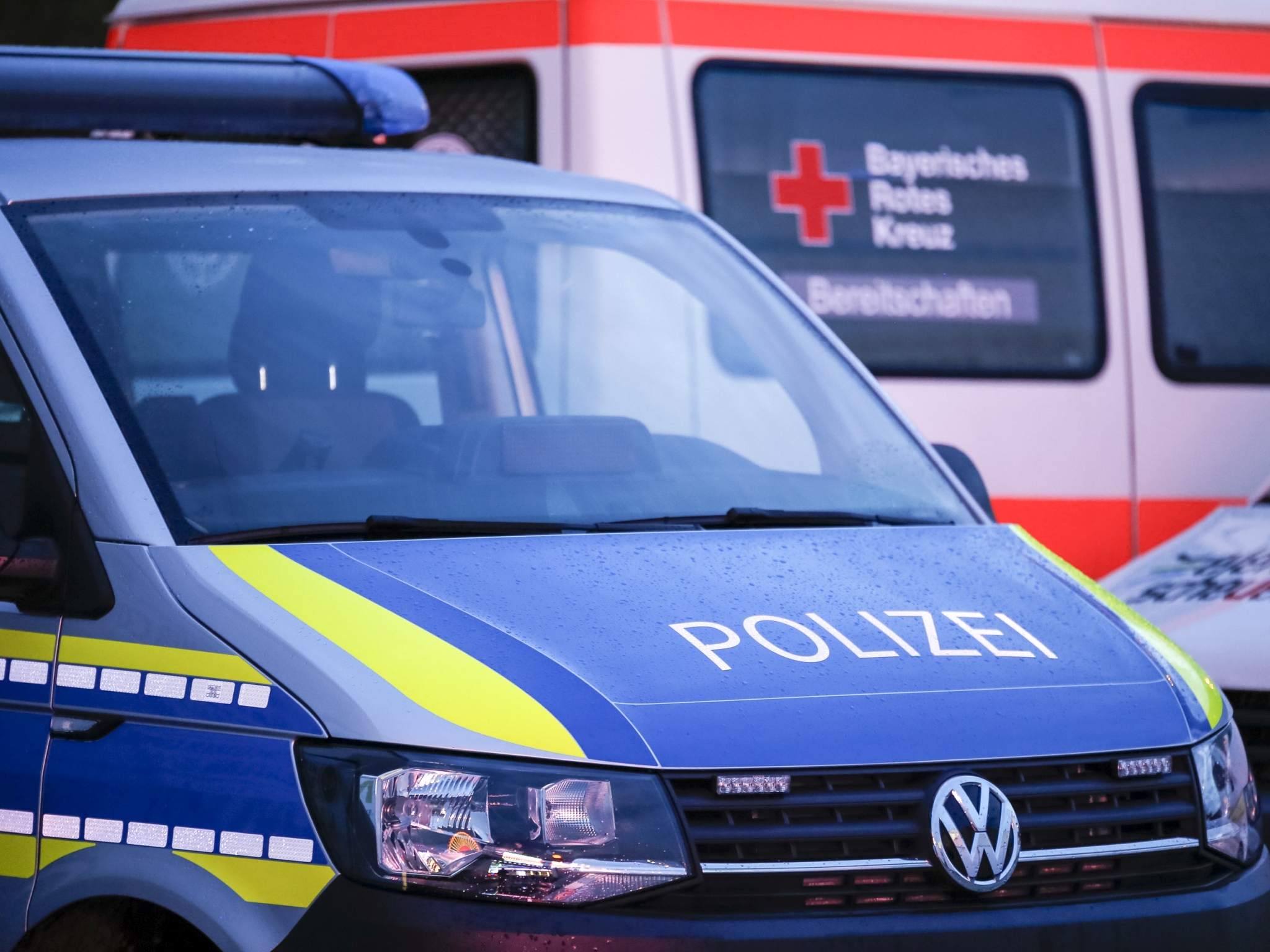 Symbolbild Polizeiwagen, im Hintergrund BRK-Auto