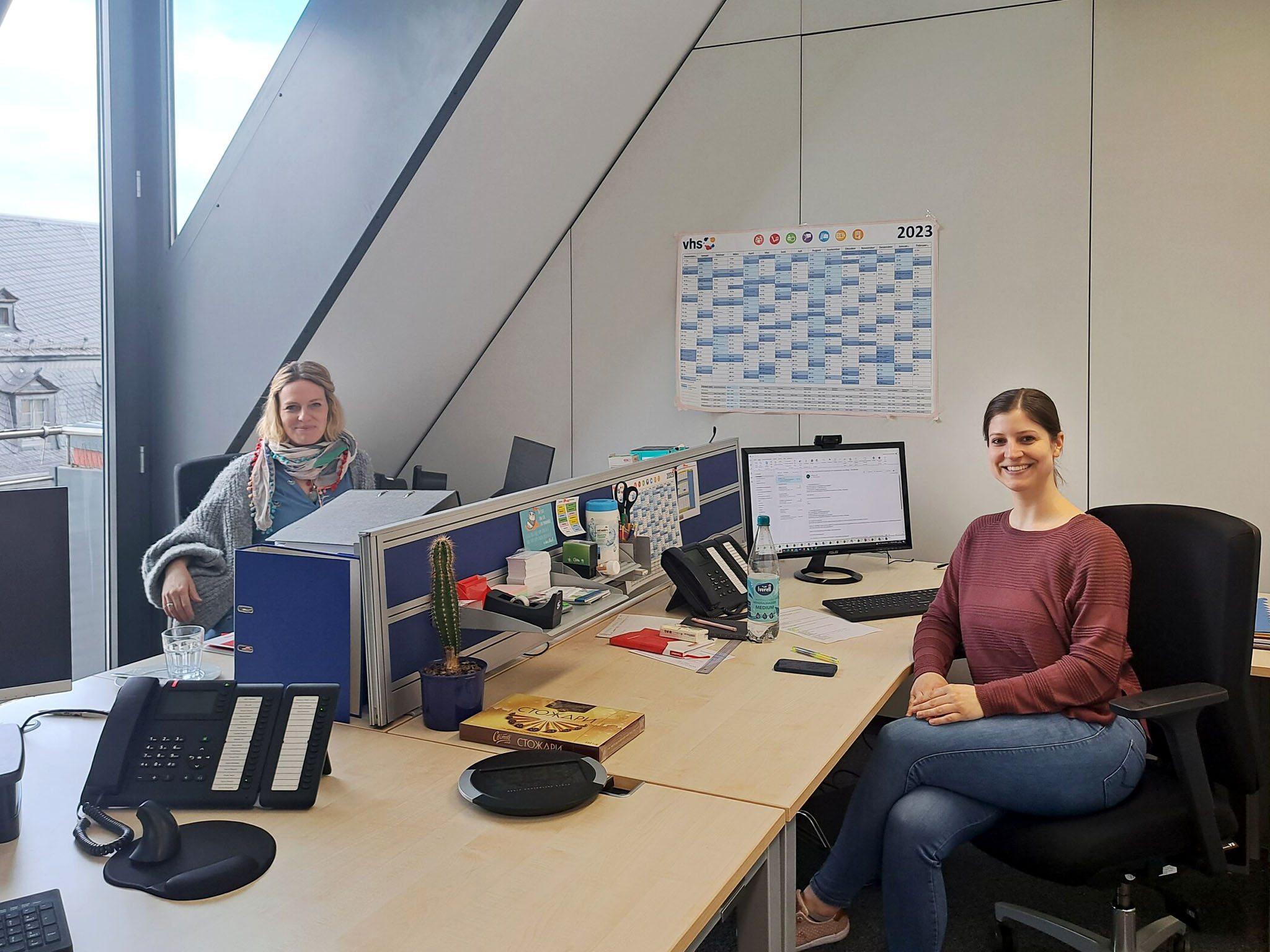Saskia Mahlstede (links), Programmbereich Sprachen, und Doreen Adam, Programmbereich Sprachen und Leiterin Prüfungskompetenzzentrum, begrüßen und beraten die Kursteilnehmerinnen und Kursteilnehmer in den neuen Räumen der vhs Würzburg & Umgebung in der Juliuspromenade.