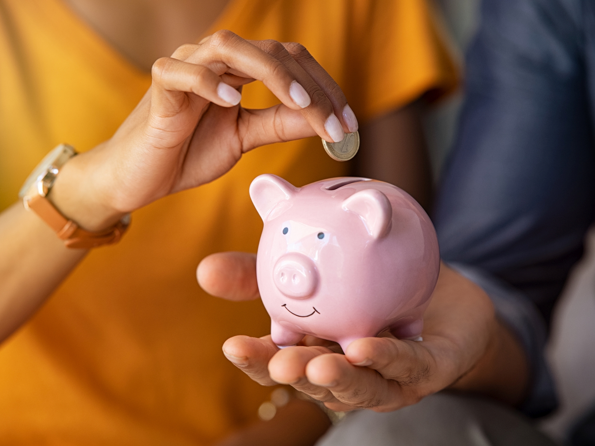 Couple saving money in piggybank