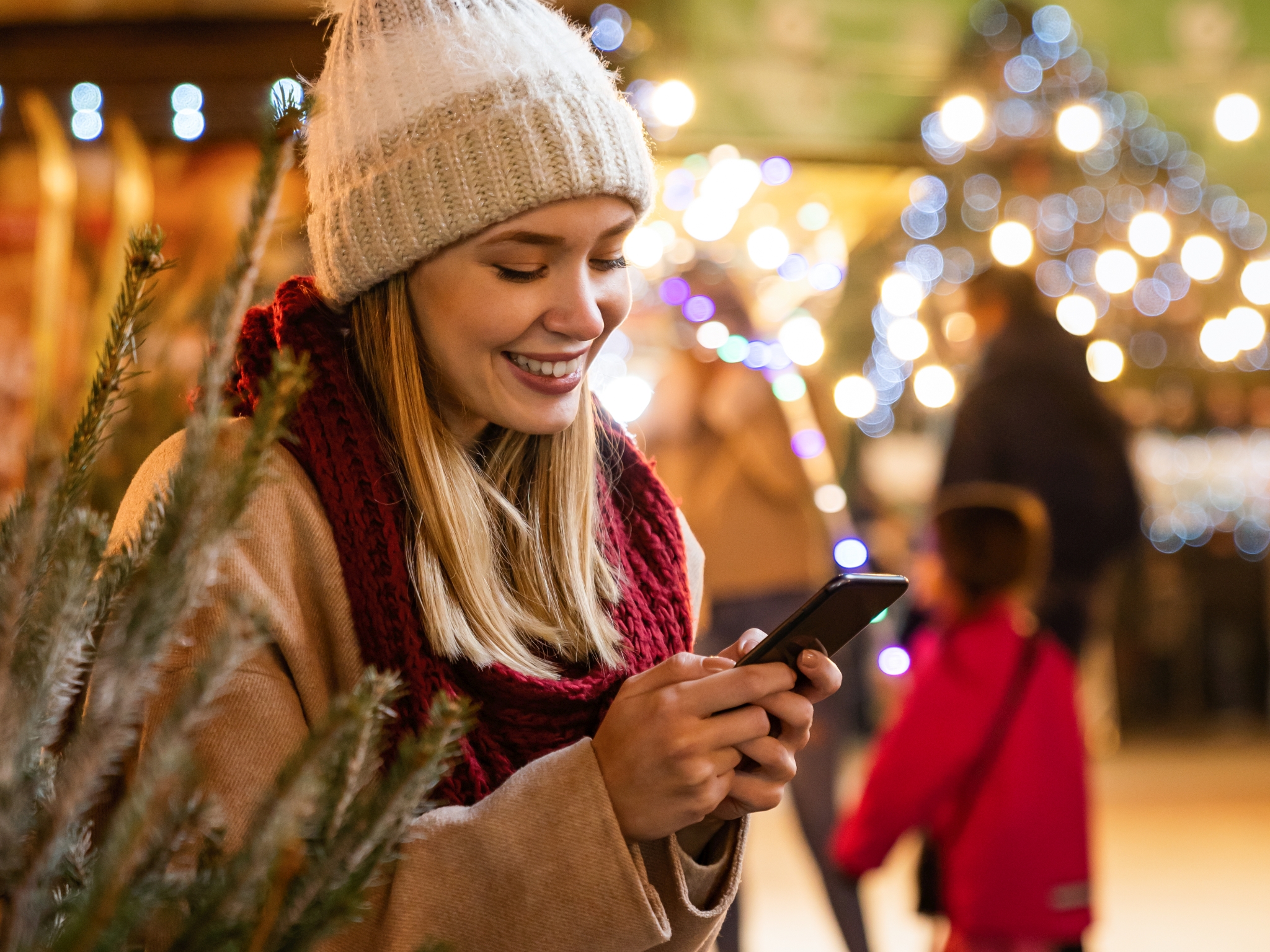 Shopping christmas travel people concept. Happy woman with shopping bag using digital device outdoor