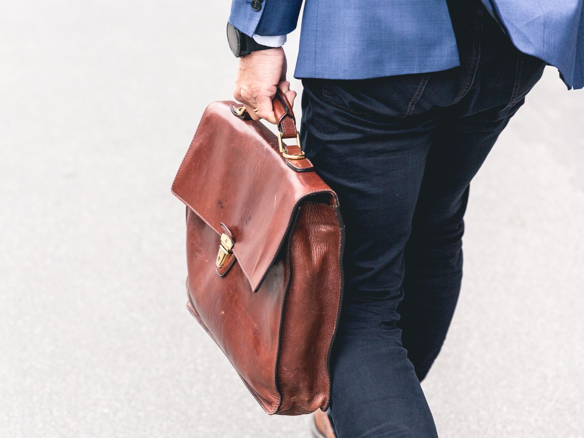 Symbolbild Arbeit Mann mit Aktentasche aus Leder in der Hand auf dem Weg zur Arbeit
